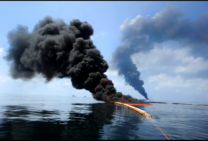 Dark clouds of smoke and fire emerge as oil burns during a controlled fire in the Gulf of Mexico, May 6, 2010. The U.S. Coast Guard, working with BP, local residents and other federal agencies, conducted the burn to help prevent the spread of oil followin