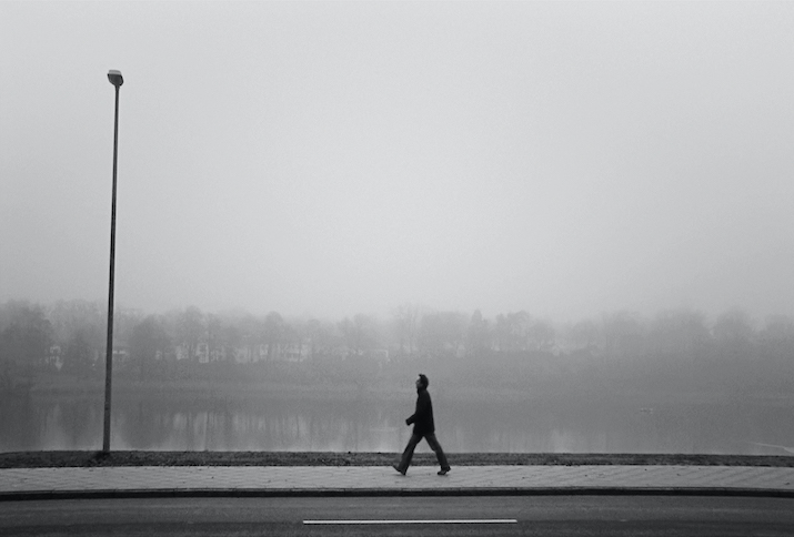 Schwarz-weiß Aufnahme eines Mannes im Profil, der eine Straße entlang läuft