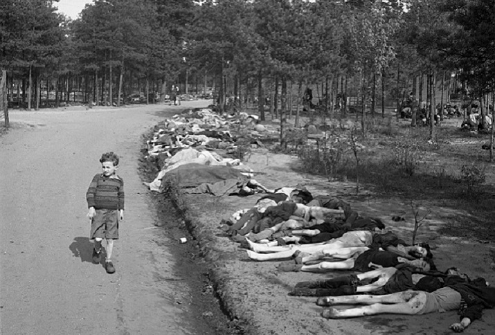 Young Boy Walks Past Corpses, dressed in shorts he walks along a dirt road lined with the corpses of hundreds of prisoners who died at the Bergen-Belsen extermination camp, near the towns of Bergen and Celle, Germany, April 20, 1945.