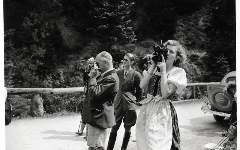 Eva Braun fotografiert, im Hintergrund Nazimänner, die ebenfalls fotografieren