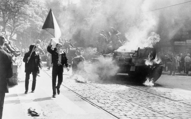 Einwohner von Prag mit tschechoslowakischer Flagge vor einem sowjetischen Panzer