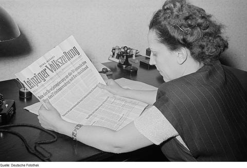 Porträt von Margarete Däumichen, die eine am 11. März 1952 zur Stalin-Note erschienene Sonderausgabe der Leipziger Volkszeitung liest.