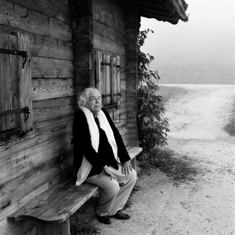 Thomas Harlan, auf einer Bank vor einer Hütte im Berchtesgadener Land sitzend, 2007.