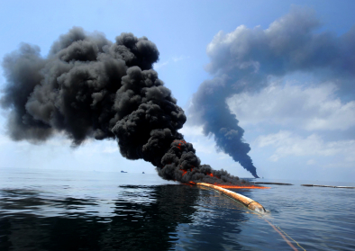 Dark clouds of smoke and fire emerge as oil burns during a controlled fire in the Gulf of Mexico, May 6, 2010. The U.S. Coast Guard, working with BP, local residents and other federal agencies, conducted the burn to help prevent the spread of oil followin