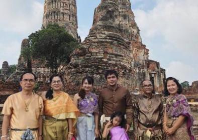 Thailändische Familie in traditioneller Kleidung vor Tempelruinen in Ayutthaya 2018