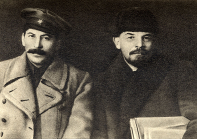 Stalin und Lenin im März 1919. In einer ersten Version des Fotos befand sich Kalinin (an der Seite Lenins) mit auf dem Bild, er wurde später wegretuschiert. 
