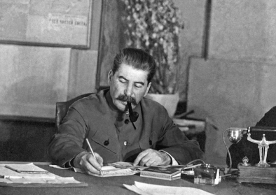 Joseph Stalin sitzt Pfeife rauchend an seinem Schreibtisch