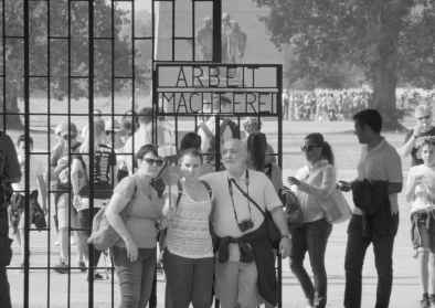 Menschen posieren vor dem Schriftzug Arbeit macht frei Menschen posieren vor dem Schriftzug "Arbeit macht frei"