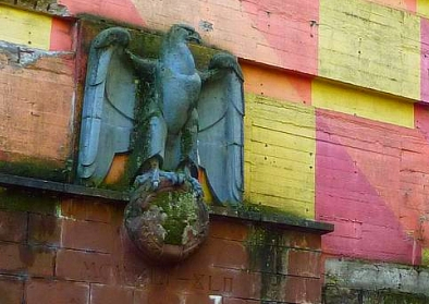 NS-Reichsadler mit entferntem Hakenkreuz am Hochbunker Boltestraße, Bochum-Werne (2010). Die Außenfassade wurde in den 1970er Jahre im Rahmen der „Aktion Schöneres Bochum“ bunt bemalt.