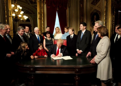 Trump am Schreibtisch umringt von Familie und Stab Trump am Schreibtisch umringt von Familie und Stab