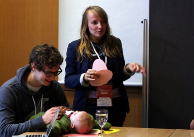 Janine Funke bei einem Vortrag mit Ihrer Tochter Emilia, die von ihrem Mann betreut wird. Foto: Janine Funke. Janine Funke bei einem Vortrag mit Ihrer Tochter Emilia, die von ihrem Mann betreut wird