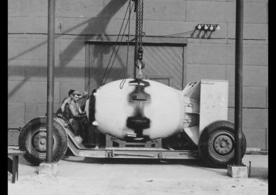Fat Man unit being placed on trailer cradle in front of Assembly Building, August 1945. Fat Man unit being placed on trailer cradle in front of Assembly Building, August 1945.