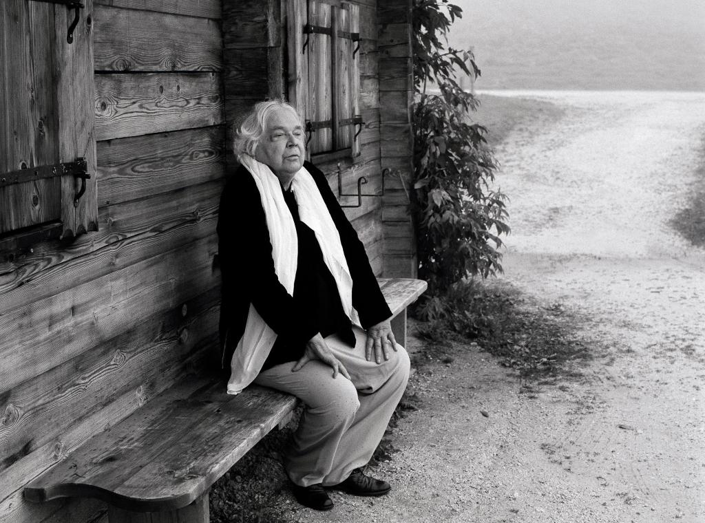 Thomas Harlan, auf einer Bank vor einer Hütte im Berchtesgadener Land sitzend, 2007.