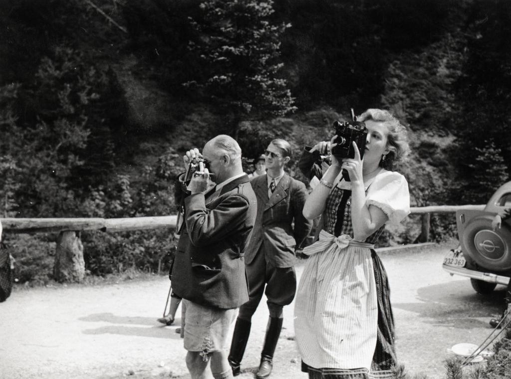 Eva Braun fotografiert, im Hintergrund Nazimänner, die ebenfalls fotografieren