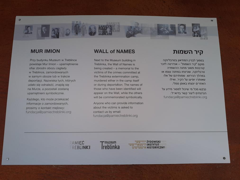 Informationstafel auf dem Parkplatz des Muzeum Treblinka. Übersetzung aus dem Polnischen: „Am Museum in Treblinka entsteht eine Mauer der Namen zum Gedenken an die Opfer des Vernichtungslagers in Treblinka, die im Lager selbst oder während der Deportationen ermordet wurden. Die Namen derjenigen, die festgestellt werden konnten, finden sich auf der Mauer, an die übrigen wird symbolisch erinnert werden. Jeden, der Informationen über die Ermordeten liefern kann, bitten wir darum, uns per Email zu kontaktieren.