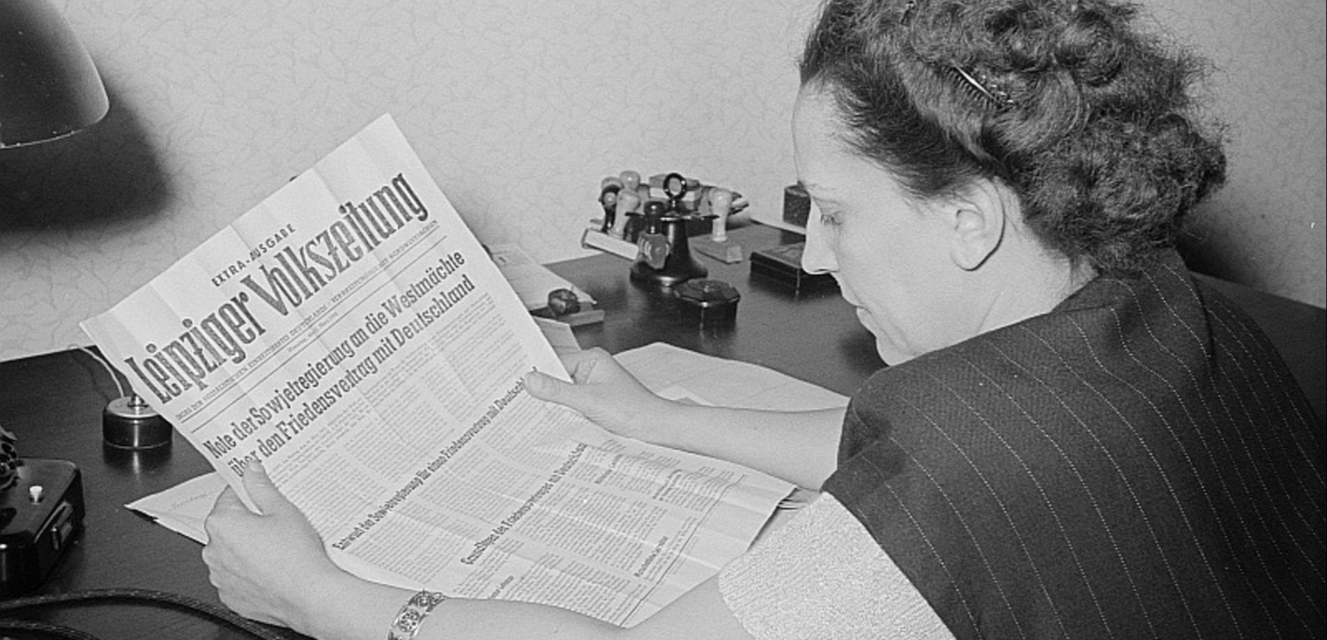 Porträt von Margarete Däumichen, die eine am 11. März 1952 zur Stalin-Note erschienene Sonderausgabe der Leipziger Volkszeitung liest.