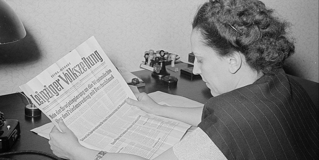 Porträt von Margarete Däumichen, die eine am 11. März 1952 zur Stalin-Note erschienene Sonderausgabe der Leipziger Volkszeitung liest. 