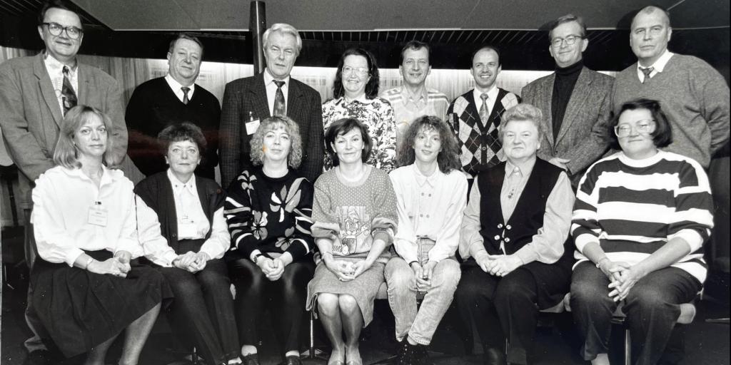 Das Bild zeigt ostdeutsche Mitarbeitende der „DAAD-Arbeitsstelle Berlin-Mitte“ (ASBM) mit dem westdeutschen Leiter des Büros (3. von links oben) auf einem Betriebsausflug in Rostock 1993. 