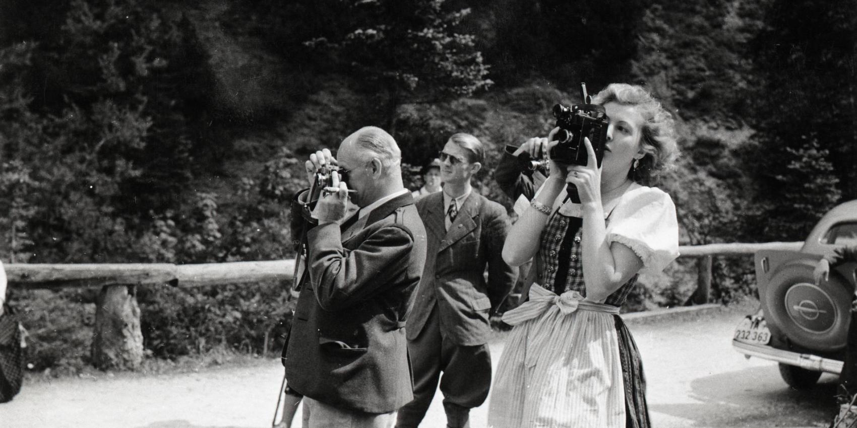 Eva Braun fotografiert, im Hintergrund Nazimänner, die ebenfalls fotografieren