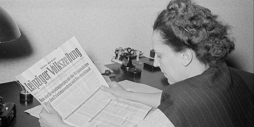 Porträt von Margarete Däumichen, die eine am 11. März 1952 zur Stalin-Note erschienene Sonderausgabe der Leipziger Volkszeitung liest. 