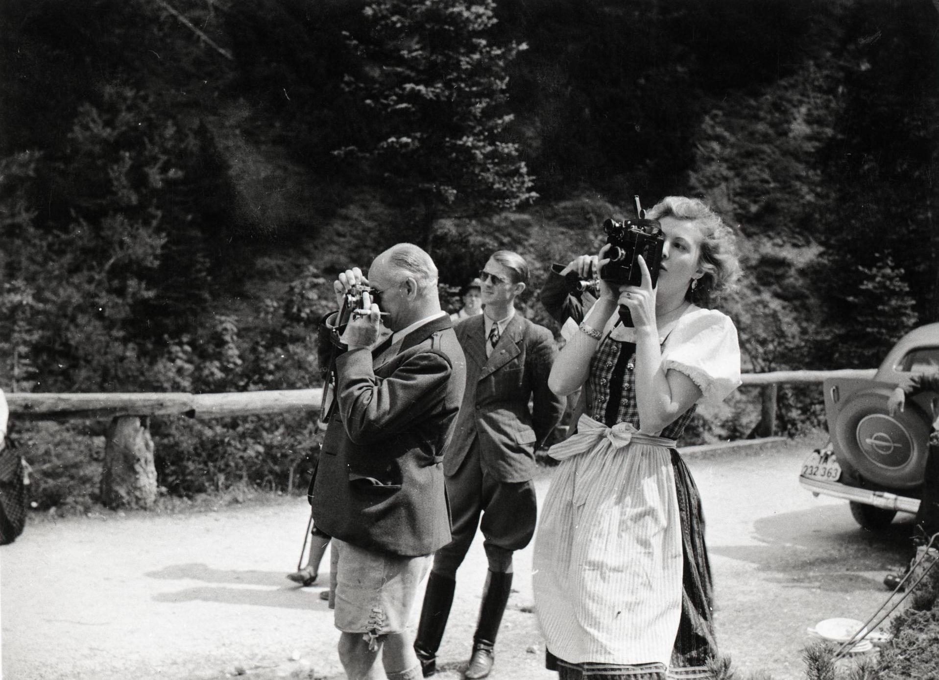 Eva Braun fotografiert, im Hintergrund Nazimänner, die ebenfalls fotografieren