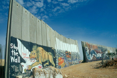 Die noch unfertige Begrenzungsmauer, die Teile von Bethlehem abtrennt um Israel vor palästinensischen Terroristen zu schützen. Die Zeichnungen scheinen von pro-palästinensischer Seite zu stammen, die dünne rote Beschriftung von pro-isralischer Seite. Eini